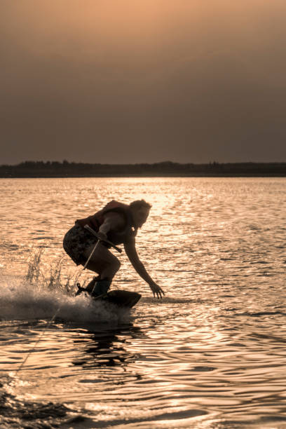 istock Young adult practicing wakeboarding, on lake at sunset. 1771798753