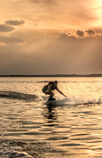 istock Young adult practicing wakeboarding, on lake at sunset. 1771798760