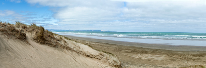 Sandy Beachscape of Ninety Mile Beach, New Zealand, with Tire Tracks Leading into the Endless Horizon of Northland's Natural Beauty, Ideal for Summer Travel, Holiday, and Outdoor Adventure Concepts
