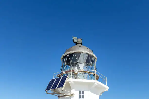 Lighthouse with Solar Panels: Sustainable Energy Solution on a Sunny Day under a Clear Blue Sky