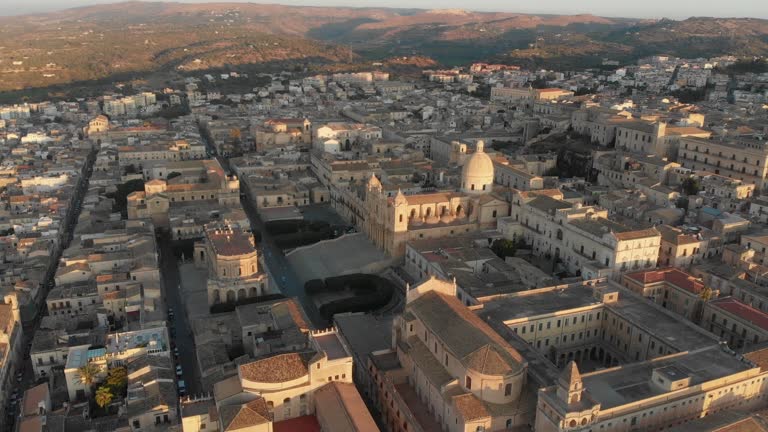 Side panning shot of famous roman catholic cathedral in Noto during sunrise, aerial