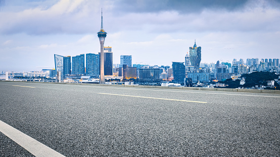 Clean asphalt road and city skyline buildings background in Macau