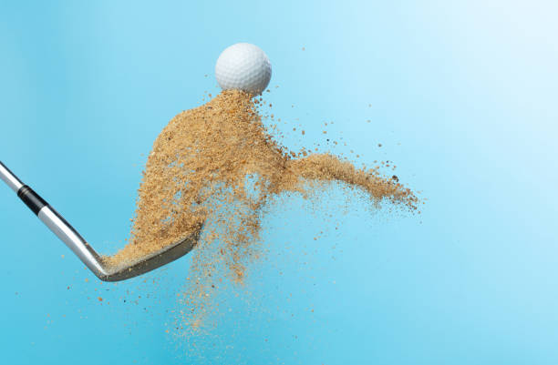 Golf ball tee explode from sand bunker. Golfer hit ball with club to sand explosion to summer sky. Golf club hit ball tee in sand wedge bunker explosion. Blue sky background isolated freeze motion el tee de la pelota de golf explota desde el búnker de arena. el golfista golpeó la pelota con el palo para la explosión de arena al cielo de verano. el palo de golf golpeó el tee de la pelota en la explosión del búnker de la cuña de arena. fondo de