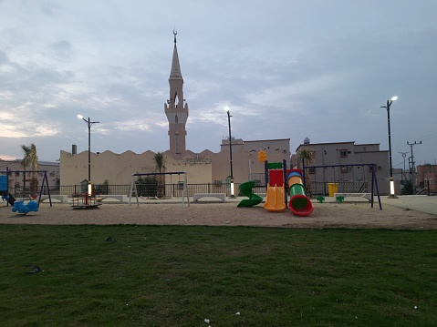 Al-Bahah area, a mosque with a garden in front of it, and games for children early in the morning
