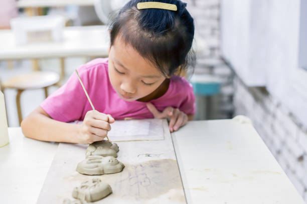 istock A girl is kneading clay in the pottery classroom 1771940443