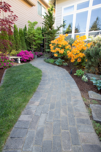 Garden Brick Paver Path Walkway with Green Grass Lawn and Landscaping Plants