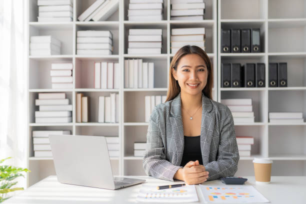 istock Asian female employee working using laptop computer at desk calculating expenses, financial reports on graph data sheet in office 1771964692