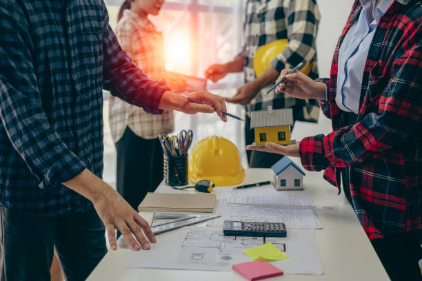 istock Engineer and businessman discussing construction project in office, team of engineers reviewing construction blueprints on new project with engineering tools at table in office 1771964743