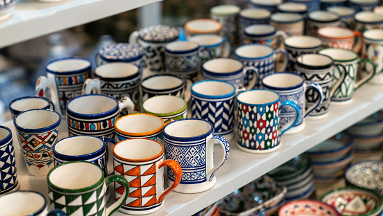 Moroccan cups with colorful ceramics and pottery displayed outside shops in the souks, or traditional markets.