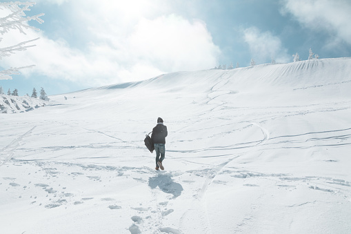 Man walking up a snow mountain alone