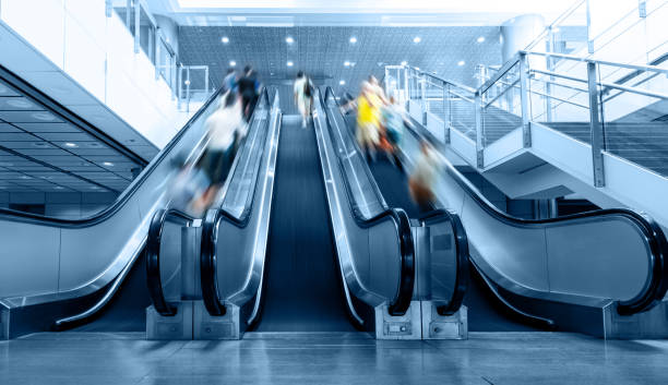 People rushing in the escalator lobby stock photo