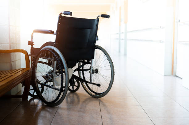 una sola silla de ruedas estacionada en el pasillo del hospital - servicio federal de protección fotografías e imágenes de stock