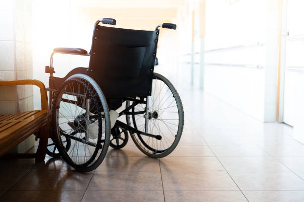 Single wheelchair parked in hospital hallway stock photo