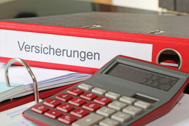 istock Symbol image: Folder (labelled Versicherungen, Insurance in German) with insurance policies and calculator on a desk (German) 1772129110