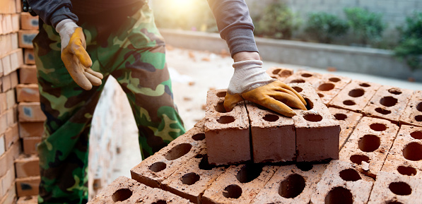 Bricklayer with brick at construction site