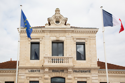French tricolor and europa flag on mairie liberte egalite fraternite text building mean city hall freedom equality fraternity in town center of biganos in france