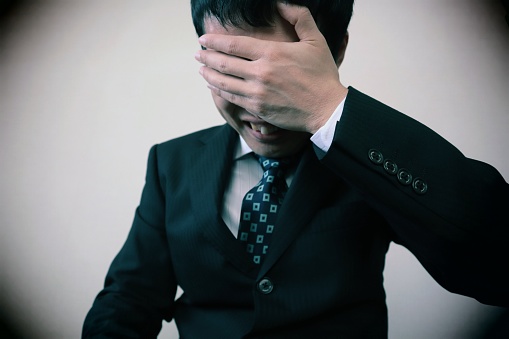 Close-up photo of depressed Japanese businessman