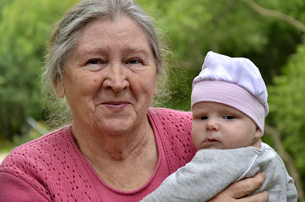 Great-grandmother and great-grandchild outdoors.