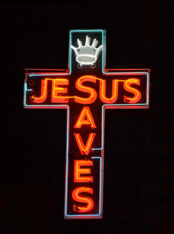 A red neon sign reading Jesus Saves
