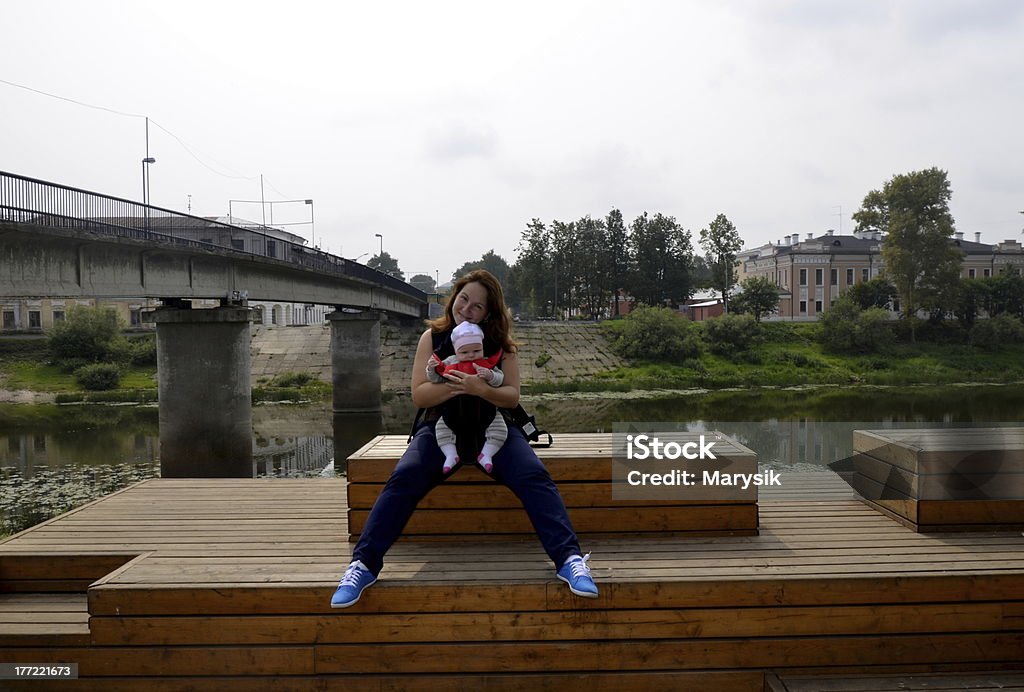 Jovem mulher com a criança às margens do rio - Foto de stock de 0-11 meses royalty-free