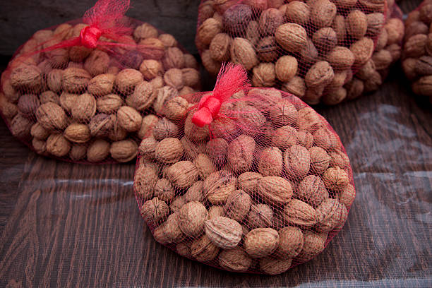 Conjunto de nueces en rojo en el mercado de agricultores bolsa de red - foto de stock