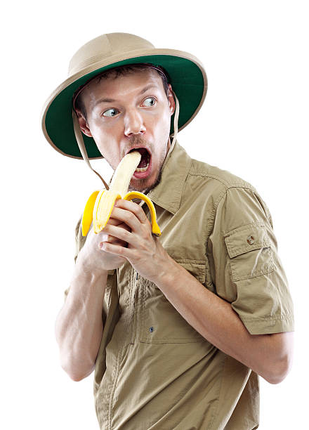 explorer nel casco coloniale mangiare banane - men banana holding cut out foto e immagini stock