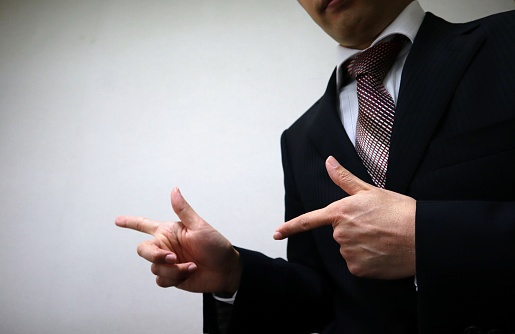 Close-up photo of a businessman pointing to the side