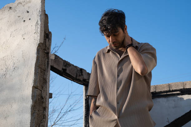 A portrait of a young man standing in abandoned place in outdoors.