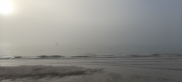 Single paddle boarder in the sea mist of Port Phillip Bay McCrae Victoria Australia
