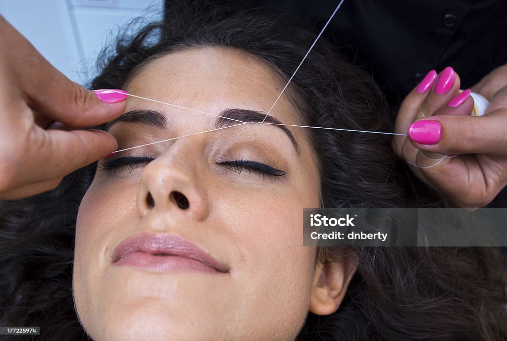 Mujer de eliminación de pelo facial procedimiento roscado - Foto de stock de Ceja libre de derechos