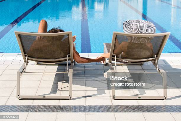 Photo libre de droit de Couple Relaxant Dans Les Chaises Longues Au Bord De La Piscine banque d'images et plus d'images libres de droit de Admirer le paysage