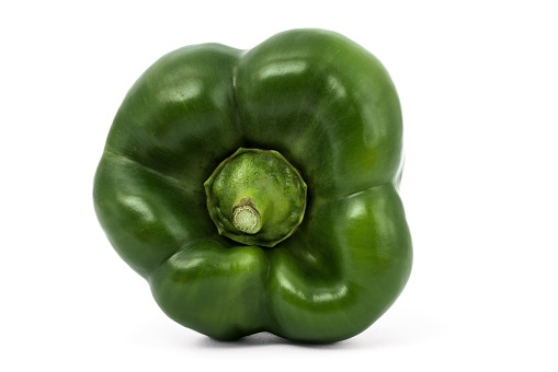 A vibrant, fresh green bell pepper trio sitting atop a white, flat surface