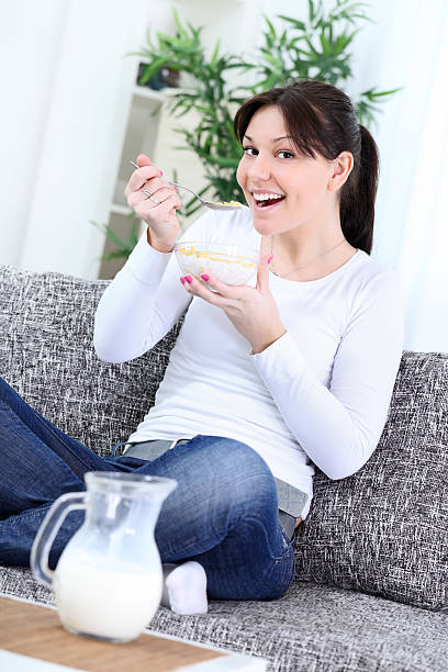 счастливая молодая женщина ест cornflakes - eating cereal student human mouth стоковые фото и изображения