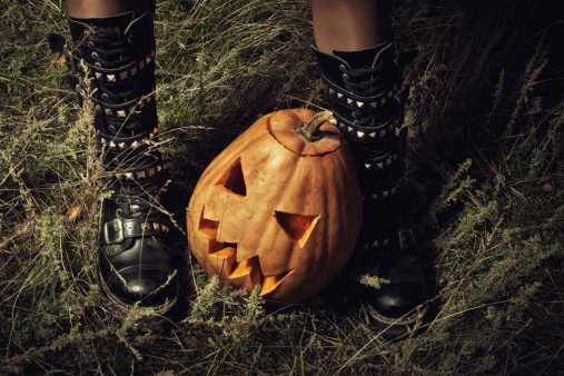 Halloween pumpkin between witch's legs