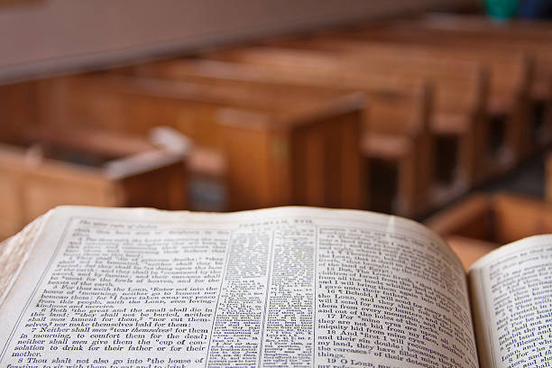 Bible open in a church with wooden chairs A bible in a church pulpit overlooking the church pew stock pictures, royalty-free photos & images