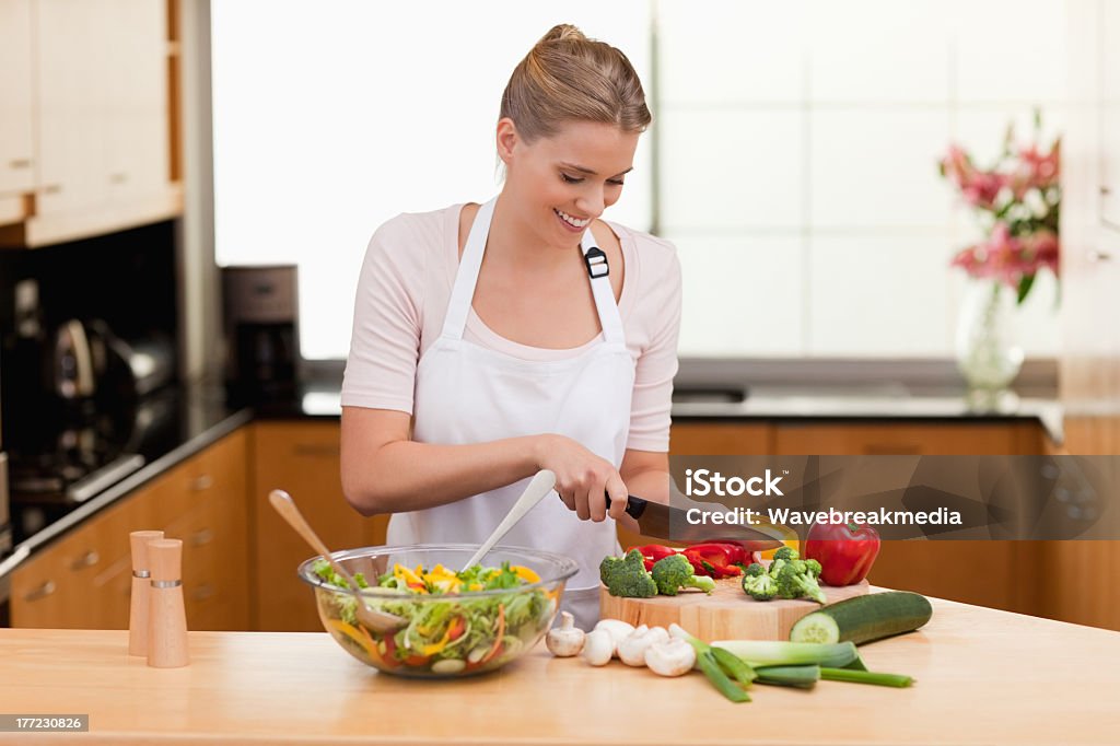 Woman slicing vegetables Woman slicing vegetables in her kitchen 25-29 Years Stock Photo