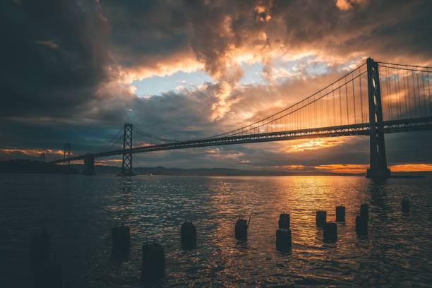 the sun sets over the bridge as it passes by on the water