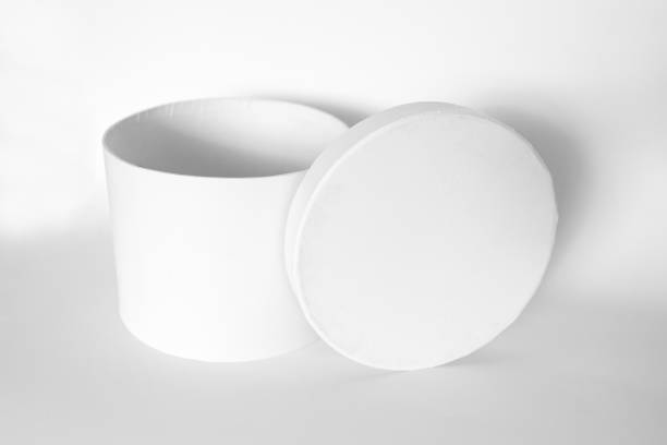 istock Single blank textured round box, gift with rope and its lid lean on it isolated on light white background. Mockup With shadow 1772315574