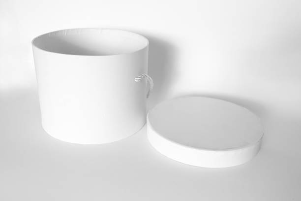 istock Single blank textured round box, gift with rope and its lid lean on it isolated on light white background. Mockup With shadow 1772316070