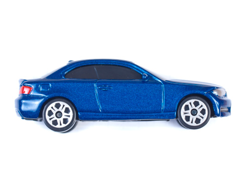 Miniature shiny blue toy car profile on a white background
