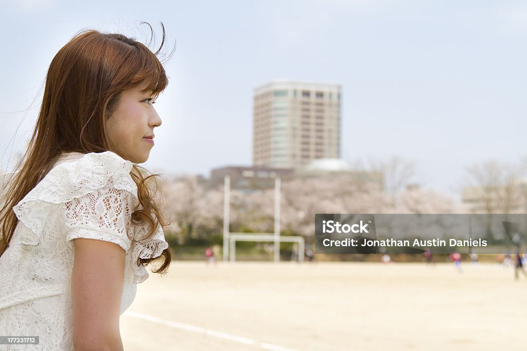 Jeune fille avec de longs cheveux bruns montres match de football à l'extérieur - Photo de Adulte libre de droits