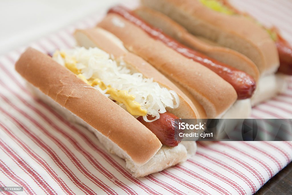 Hot Dogs with Sauerkraut and Mustard "Hot Dogs dressed with sauerkraut and yellow mustard, and with relish and ketchup." Hot Dog Stock Photo