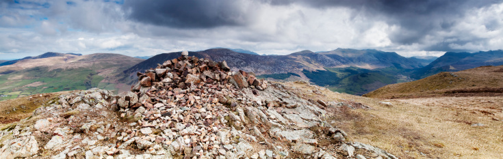 Crag Fell is Lake District mountain in the Ennerdale area of Cumbria. This shot was taken from the summit overlooking the picturesque area of Ennerdale. The cairn (pile of rocks) symbolises the summit. Walkers are encouraged to place their own rock on the cairn. The area was surrounded by rain clouds that can be seen in the distance.