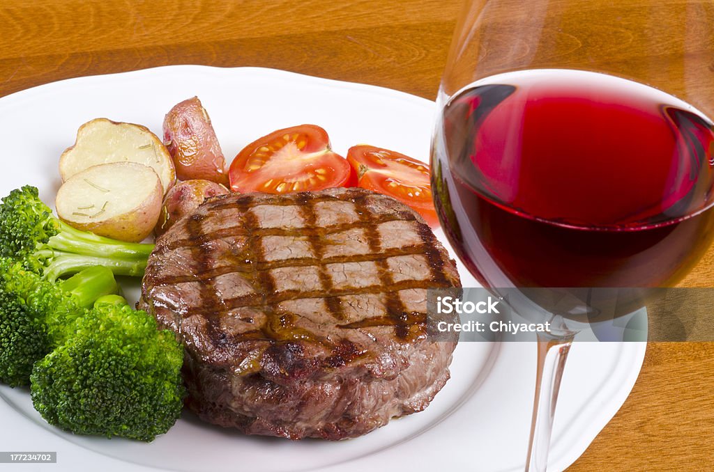 Barbecued Beef Steak and a Glass of Red Wine Barbecued rib eye steak served with vegetables and a glass of red wine. Alcohol - Drink Stock Photo