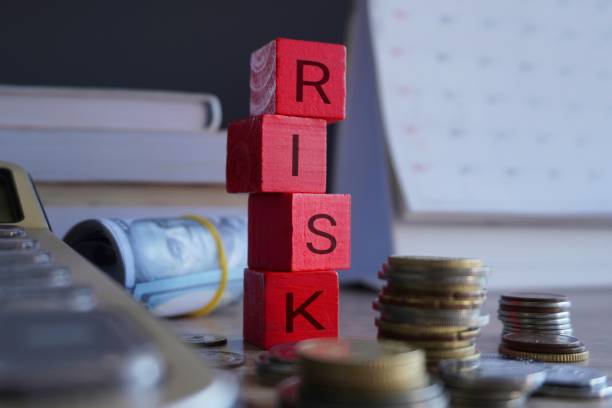 istock Wooden cubes with text RISK surrounded by calculator and money. 1772347852