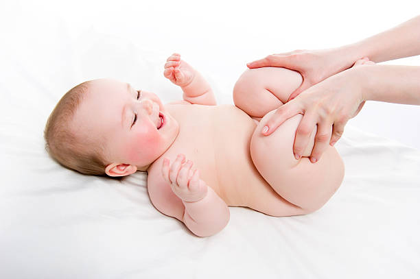 istock Mother massaging baby's legs on white sheet 177234820