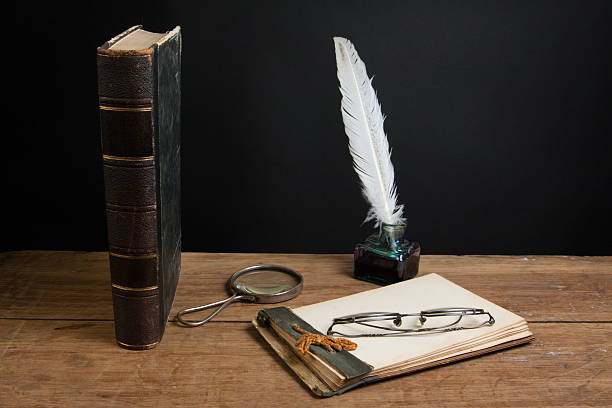 istock Notepad, quill, inkwell, magnifying glass, book, spectacles on wooden table 177235016