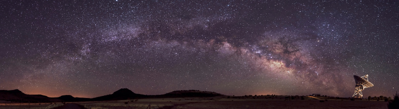 Panorama image of the Milky Way arching towards the Radio Telescope near Fort Davis, Texas