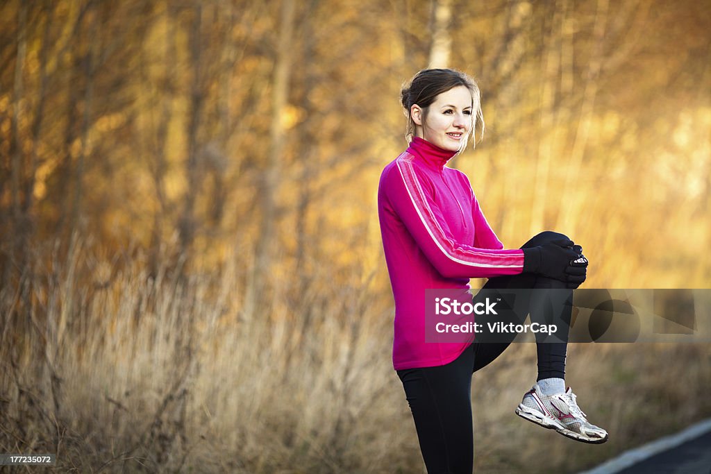 Young woman stretching before her run Young woman stretching before her run outdoors on a cold fall/winter day Active Lifestyle Stock Photo