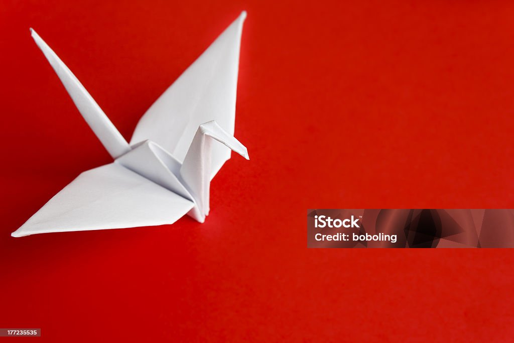 White paper bird A white paper bird on a red background Paper Crane Stock Photo